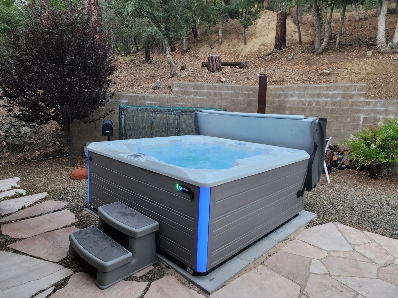 Hot tub on the paver patio, framed by granite and pines