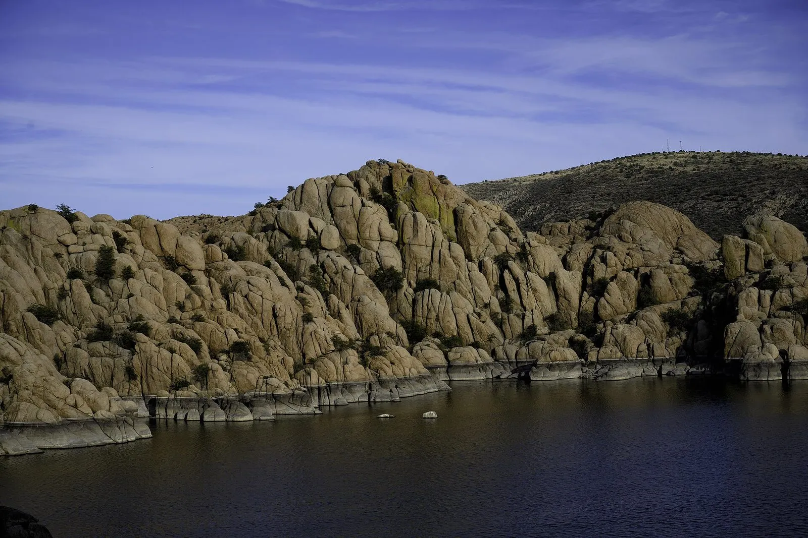 Granite boulders rising straight out of the blue water at Watson Lake in the Granite Dells